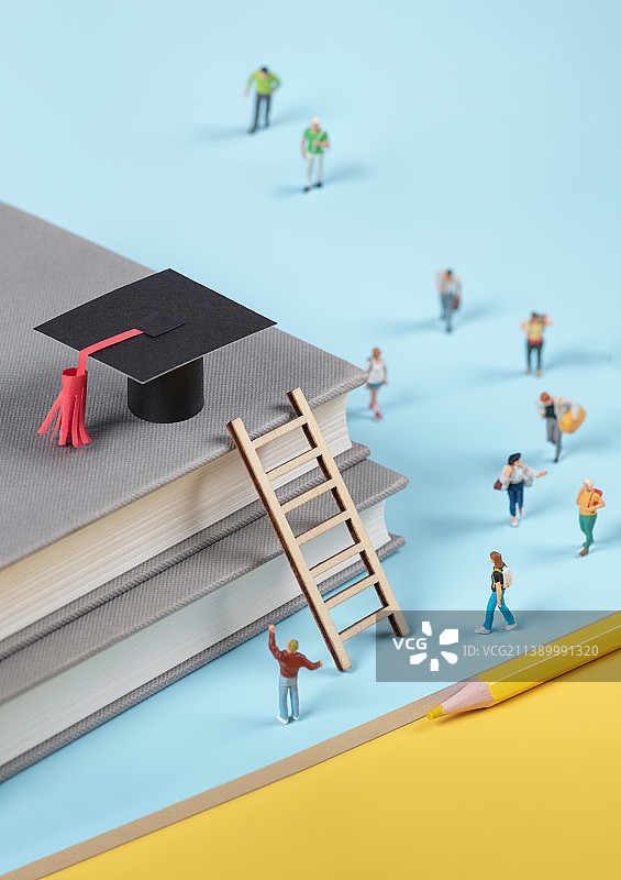 微缩创意人群奔向书本阶梯上的博士帽图片素材