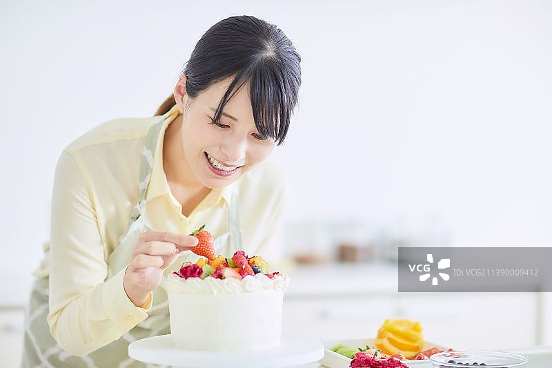 在厨房里做蛋糕的日本女人图片素材