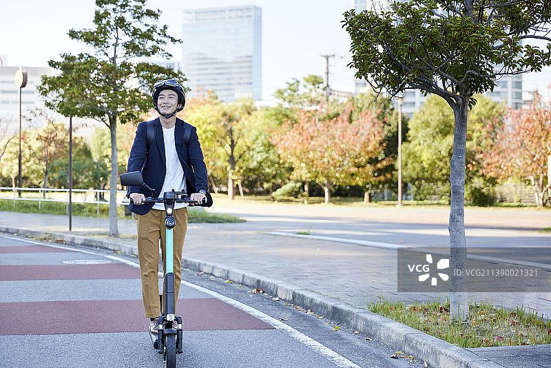 骑电动滑板车的日本男人图片素材