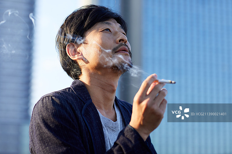 在室外吸烟的日本男人图片素材