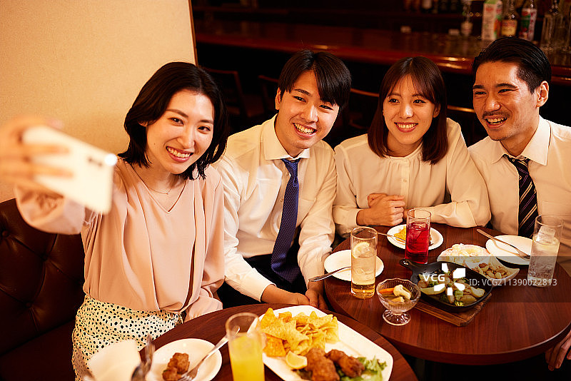 在日本酒吧喝酒和用餐的商人图片素材