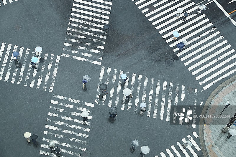 人们在雨天于日本东京的十字路口过马路图片素材
