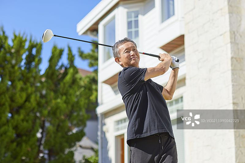 在家打高尔夫球的年长日本男人图片素材
