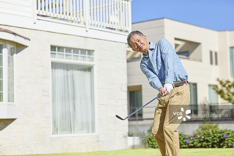 在家打高尔夫球的年长日本男人图片素材