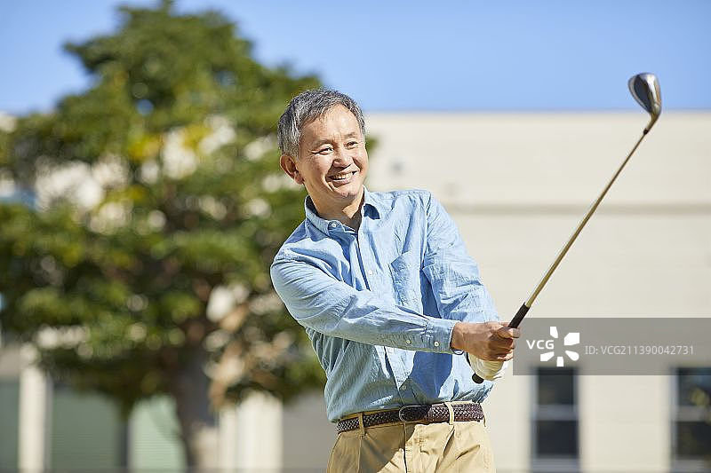 在家打高尔夫球的年长日本男人图片素材