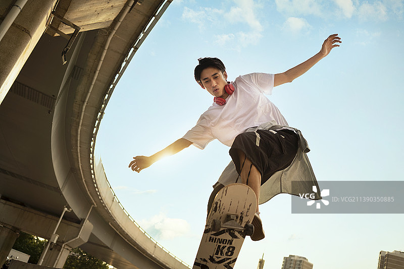 年轻男子滑滑板做极限动作图片素材