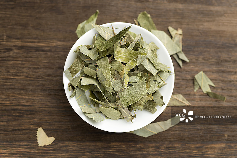 一盘滋补中药淫羊藿摆放在木桌面上特写图片素材