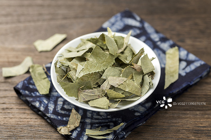 一盘滋补中药淫羊藿摆放在木桌面上特写图片素材