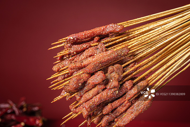 把辣椒面撒在滋滋冒油的牛肉串上图片素材