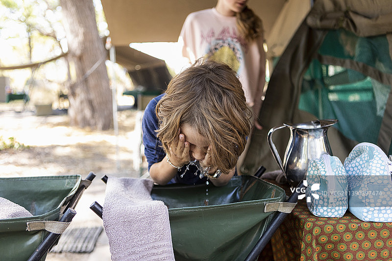 博茨瓦纳奥卡万戈三角洲：男孩在营地洗脸图片素材