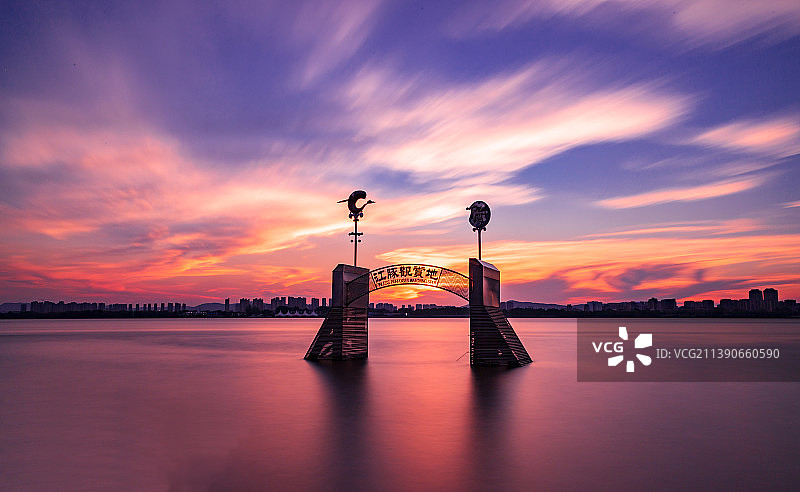 夏季汛期，江水丰盈，“海豚观赏地”标志浸入晚霞映红的江水中，格外醒目。南京，江边路图片素材