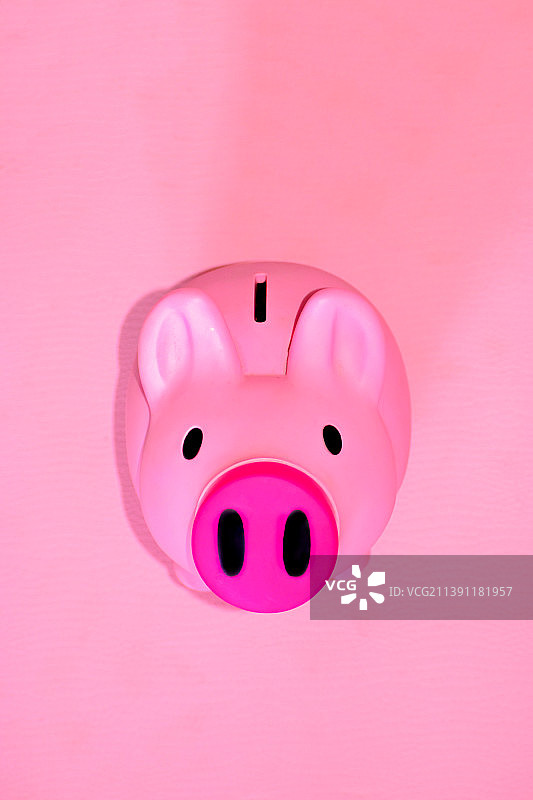 粉色背景上的小猪储蓄罐特写图片素材