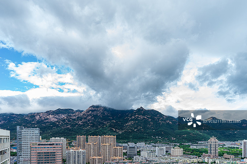 中国城市市风光拍摄主题，山东省泰安市泰山区，傲崃峰山脉和天空的乌云和城市居住区，户外白昼无人图像摄影图片素材