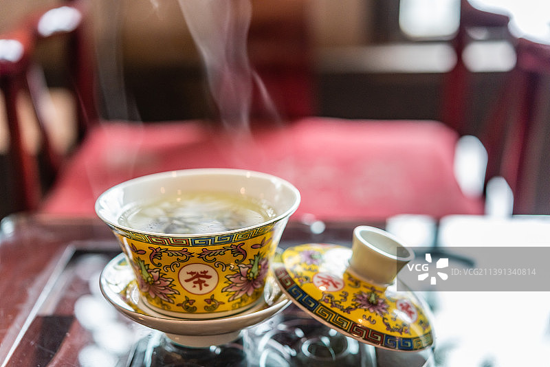 中国风古建筑背景前的茶水茶杯图片素材