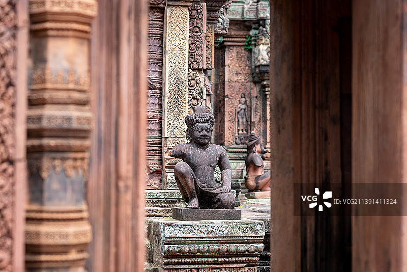 吴哥窟精美繁复的石雕历经沧桑战火留下岁月的印记，呈现出暗红色和焦黑色的断壁残垣图片素材