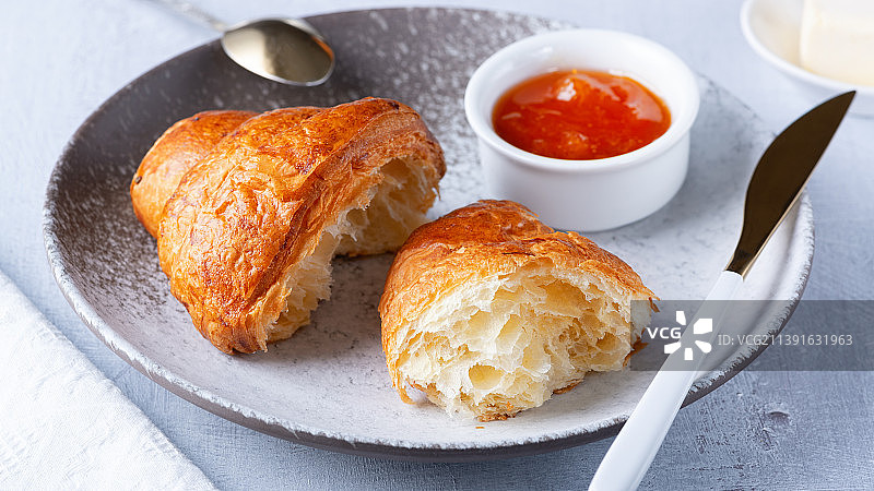 新鲜出炉的法式牛角包，黄油和果酱图片素材