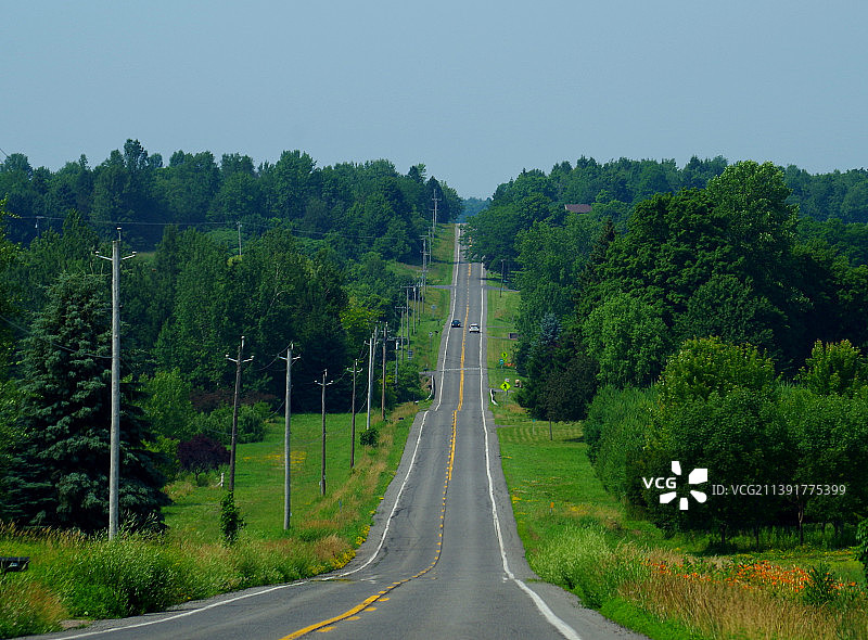 空旷的道路，树影映衬着天空图片素材
