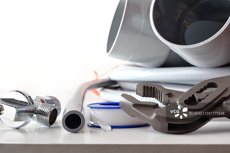 白色桌子上用于管道维修的工具细节图片素材
