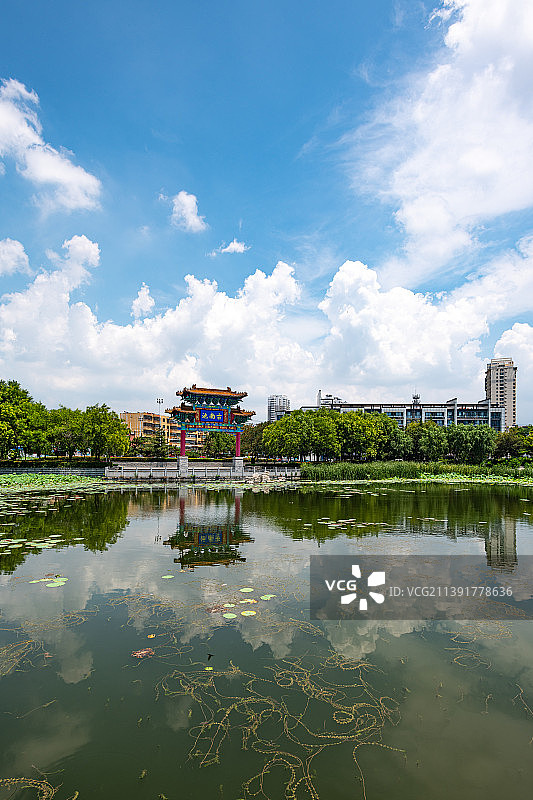 蓝天白云背景映衬下的山东济宁南池公园古南池牌坊倒影风光图片素材
