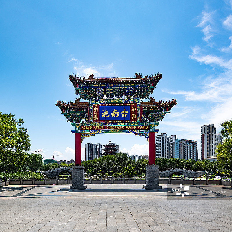 夏日蓝天白云背景映衬下的山东济宁南池公园古南池牌坊图片素材