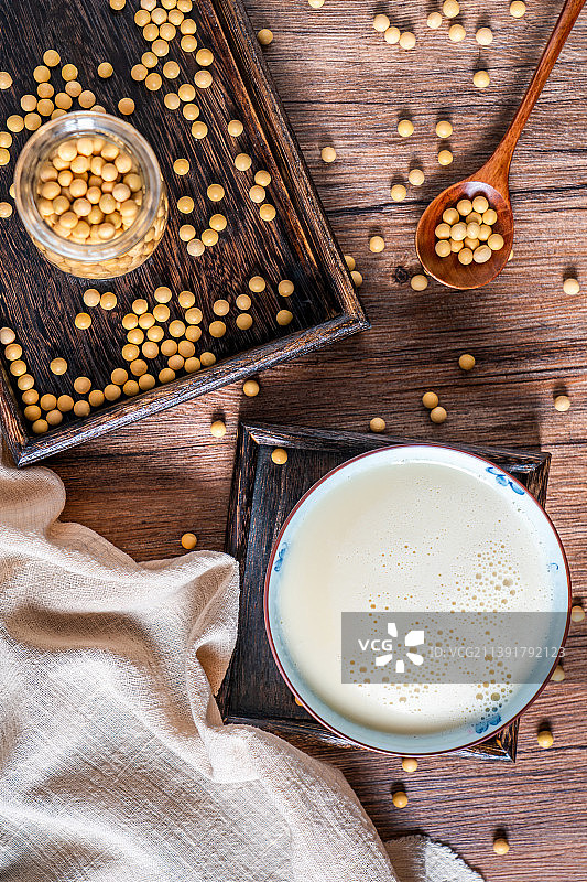 洒在桌面上的许多大豆和一碗豆浆图片素材