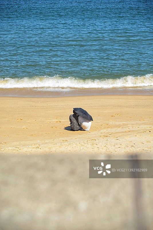 海滩上相互依偎的两人图片素材