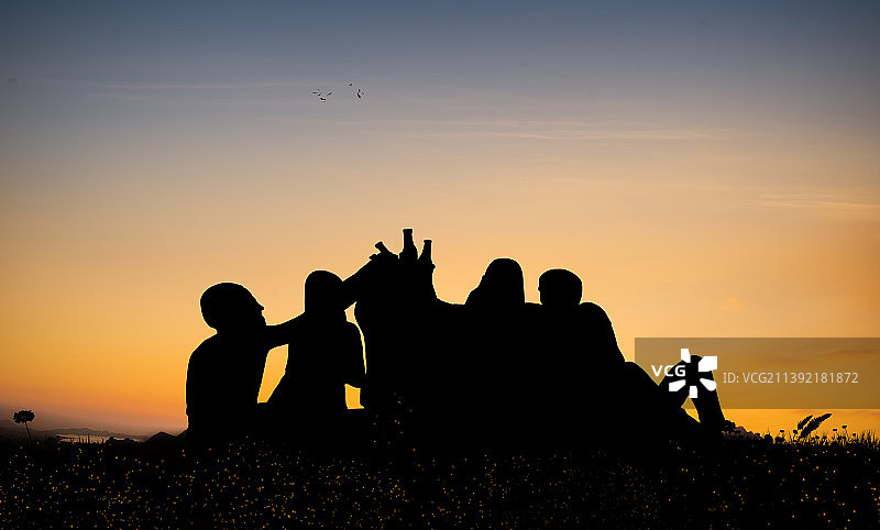 好朋友在湖边一起干杯喝啤酒，庆祝啤酒节图片素材