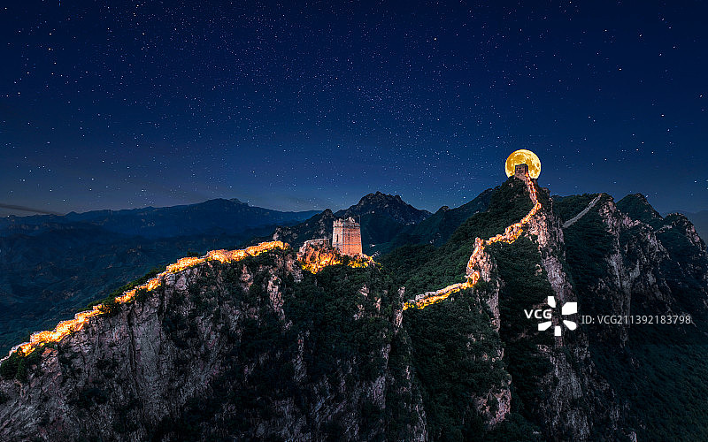 深邃星空巨大月亮映衬下的北京市密云区司马台长城图片素材