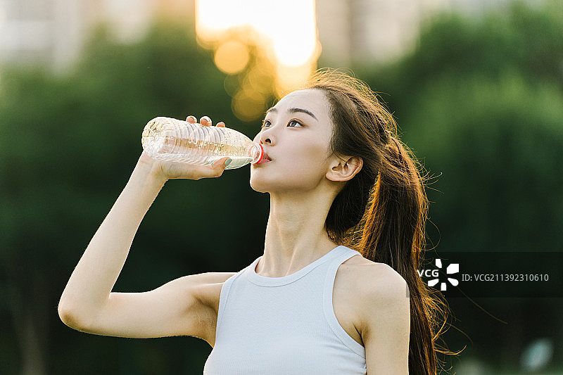 穿运动服的年轻女性在喝水图片素材