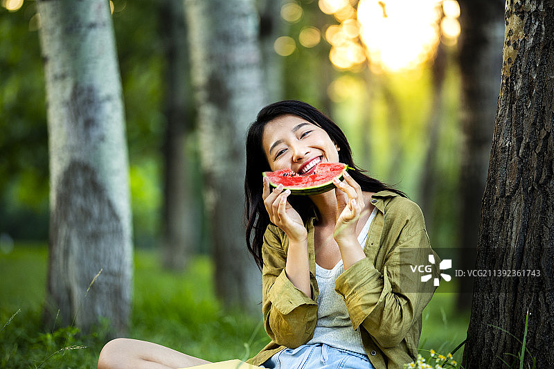 青年女子在公园吃西瓜野餐郊游图片素材