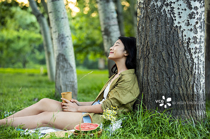 年轻女孩拿着咖啡杯在公园野餐郊游休息放松图片素材