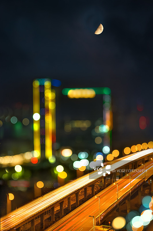夜晚城市车流灯光光斑散光中的高架立交与建筑图片素材