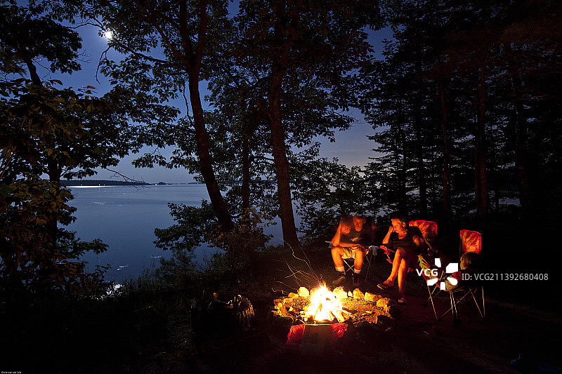 夜晚湖边营火旁的家庭图片素材