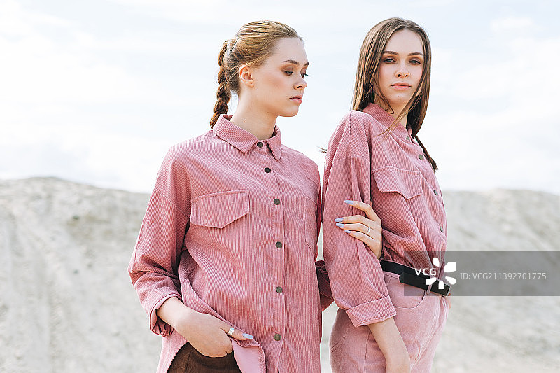 粉色有机丝绒衬衫姐妹的时尚美妆写真，沙漠背景图片素材