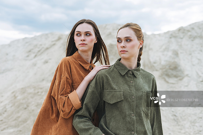 沙漠背景下的年轻姐妹天鹅绒衬衫时尚写真图片素材