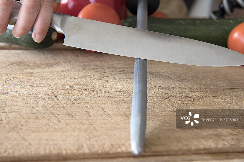 用刀在砧板上切东西的手部特写图片素材