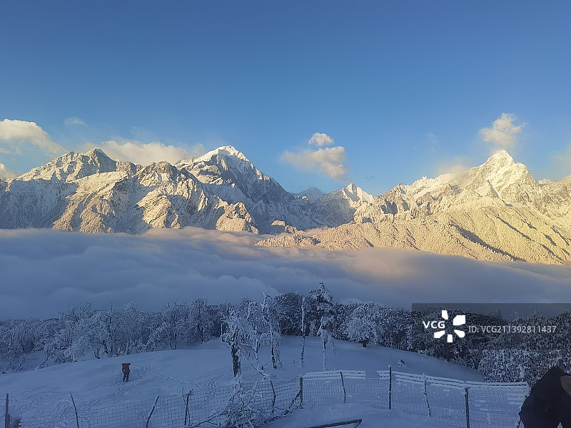 白雪皑皑的群山映衬着多云的天空图片素材