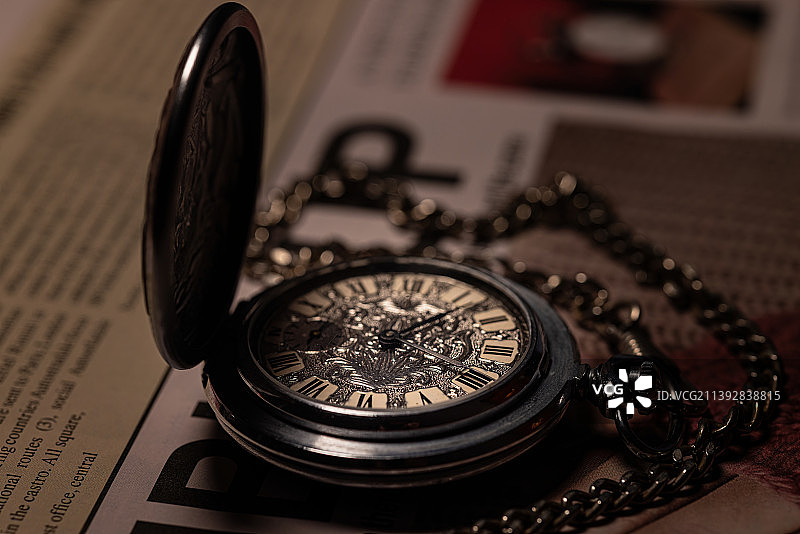英文报纸上老怀表表盘微距特写镜头图片素材