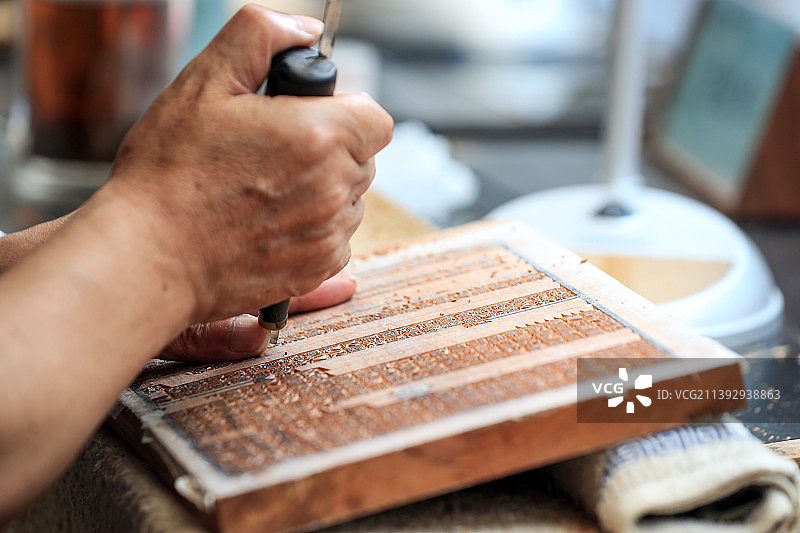 一个非遗传人正在雕刻文字，雕版印刷图片素材