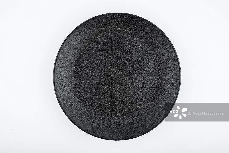 白背景上一只黑色磨砂盘子菜碟图片素材