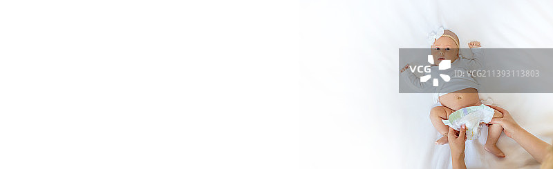 妈妈正在给宝宝换尿布（选择性焦点）图片素材