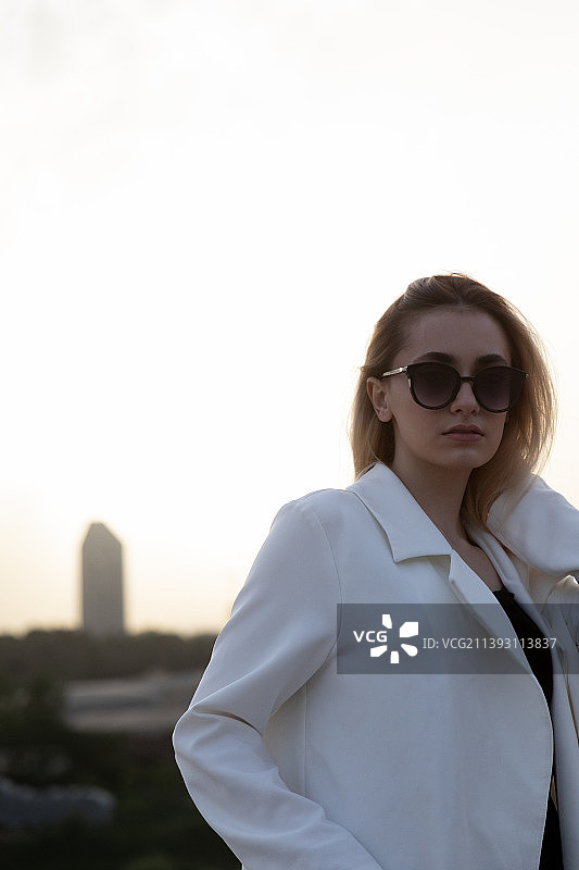日落时分戴太阳镜的年轻女人像图片素材