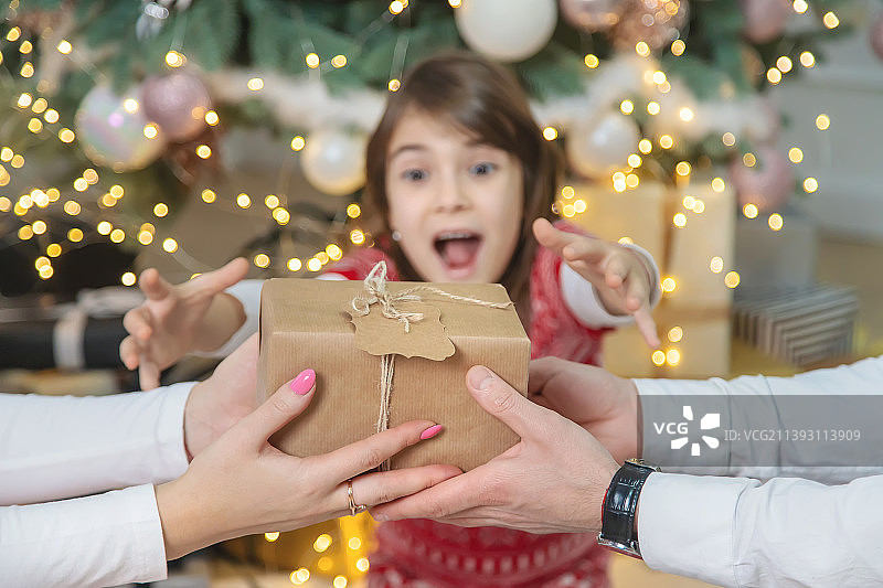 圣诞节，父母给女孩送礼物（选择性聚焦）图片素材
