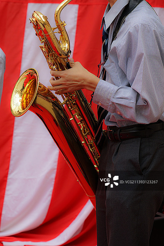 男子吹萨克斯管的腰部特写图片素材