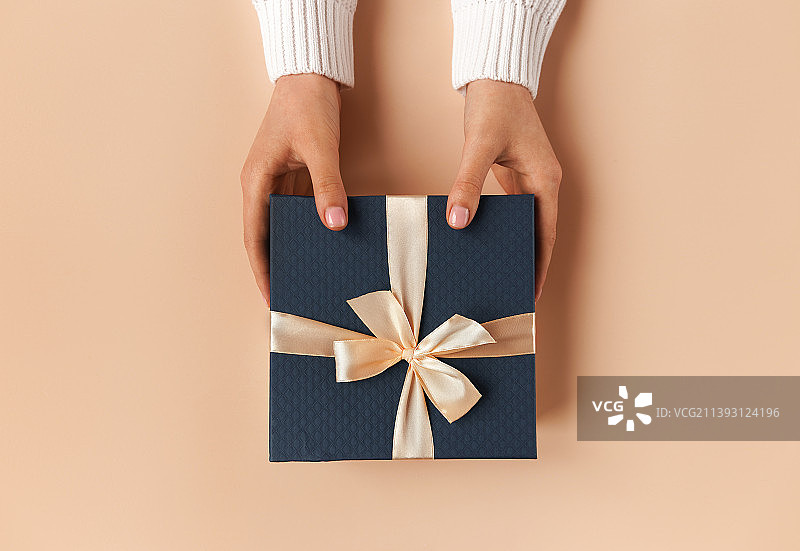自然美甲的女人手拿蓝色礼品盒图片素材