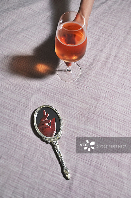 手持玫瑰红酒杯与复古镜子图片素材