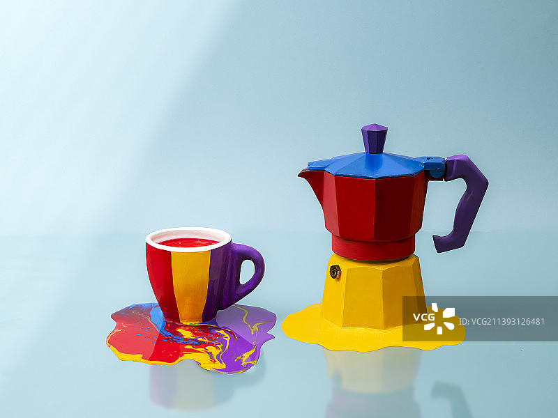 意大利巴里，蓝色背景下的彩绘咖啡渗滤壶和陶瓷杯图片素材