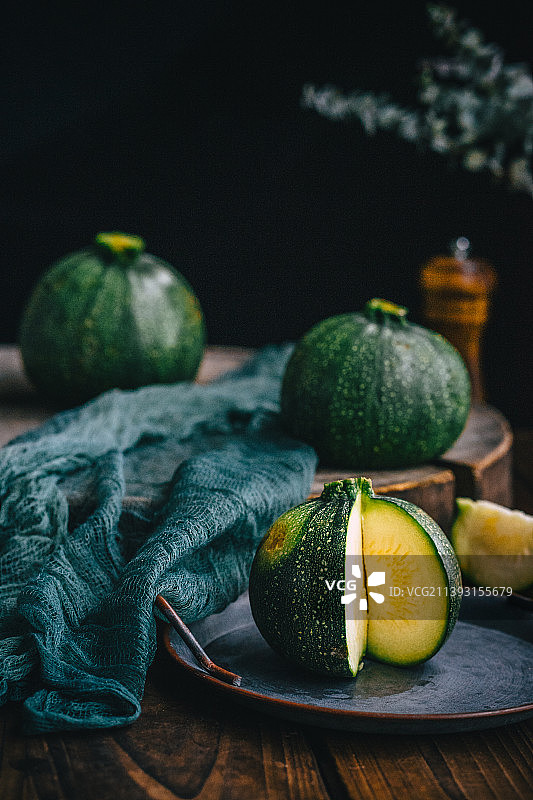 新鲜的日本小南瓜，切开摆放在砧板上图片素材