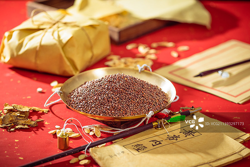 放在金色秤盘子里的中药莱菔子图片素材