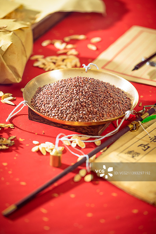 放在金色秤盘子里的中药莱菔子图片素材